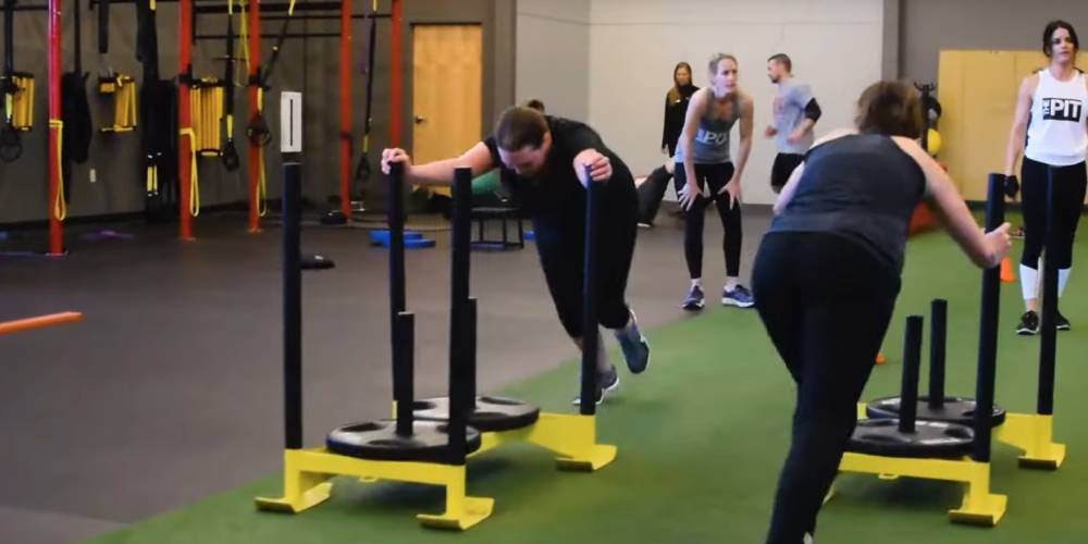 Gym members pushing sleds in a class at Four Seasons fitness club