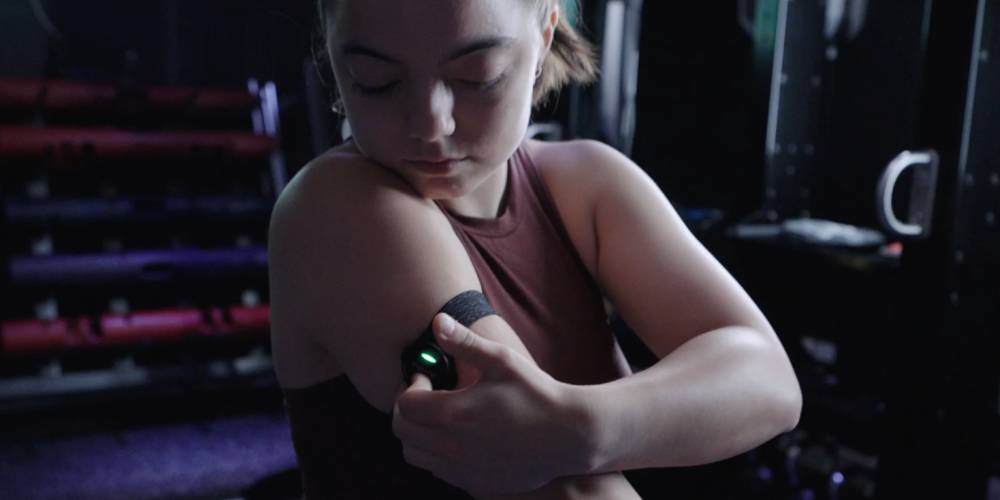 Evie Waring in a gym turning on her heart rate monitor on her arm