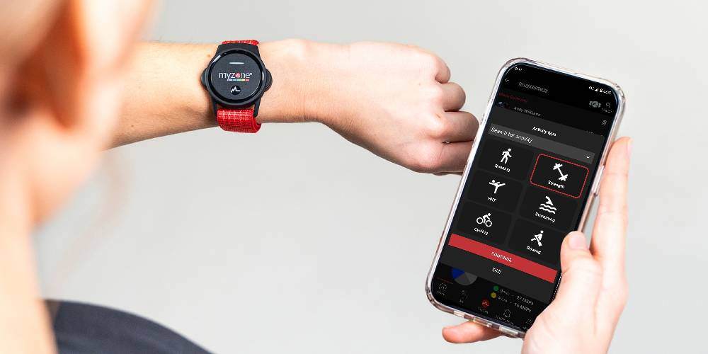 Someone wearing the Myzone Switch heart rate monitor, looking at the Myzone app